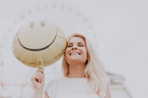 girl smiling with a happy face balloon